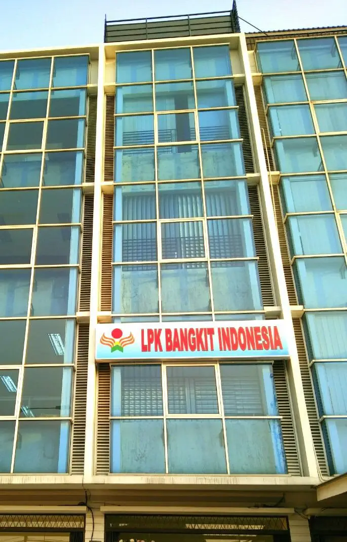 Facade of a modern building featuring large glass windows and a sign that reads "LPK Bangkit Indonesia" in bold red letters.