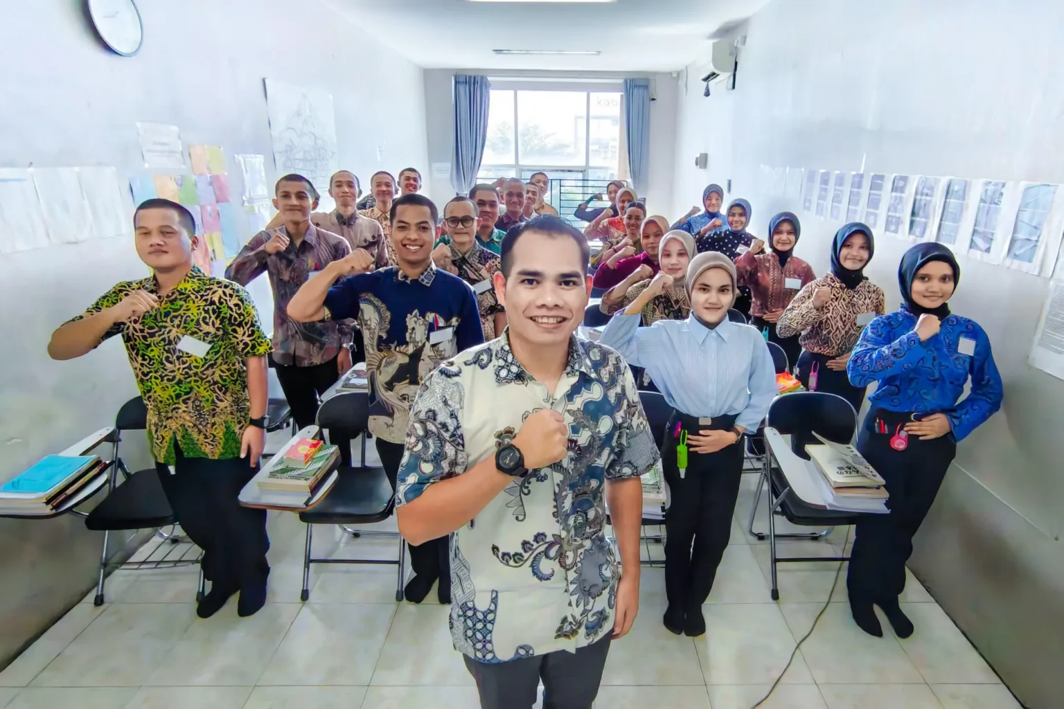 A group of individuals in patterned shirts stand in a classroom.